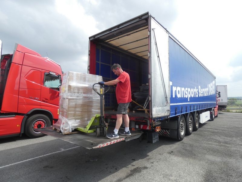 Un homme effectue une livraison avec un camion Transports Bernard Diguet